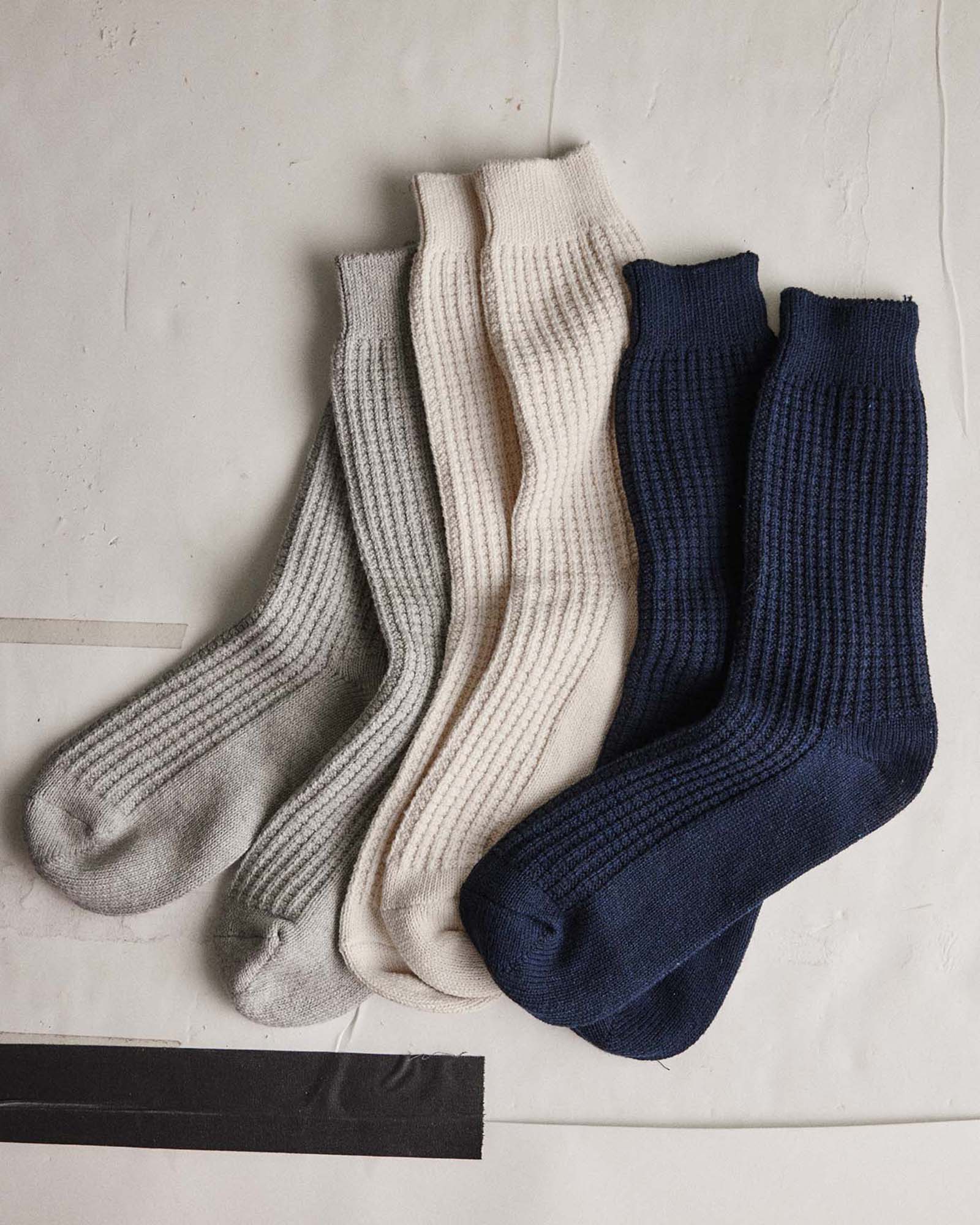 editorial flatlay of The Waffle Sock in Natural next to other socks, Accessories by Taylor Stitch