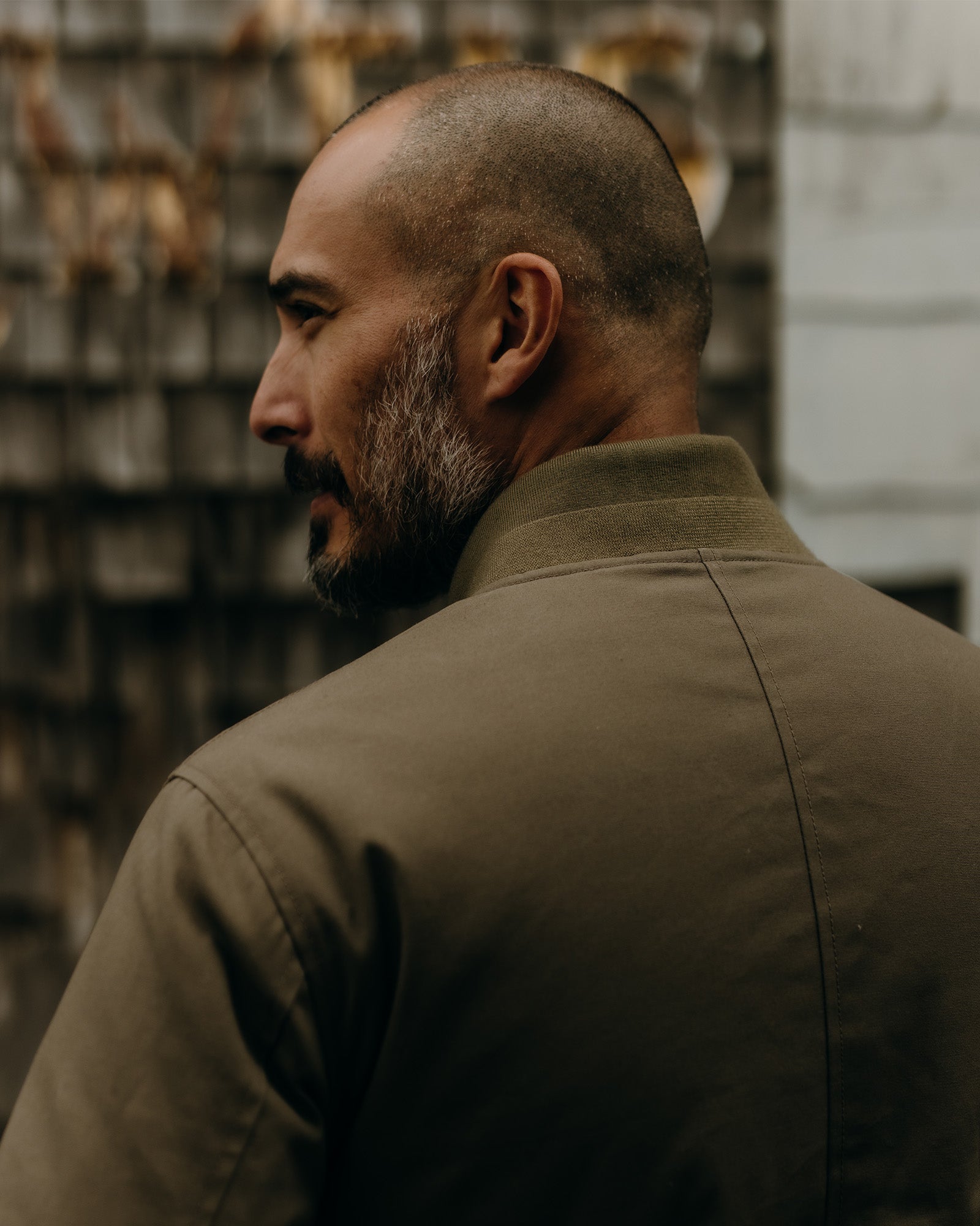 fit model wearing The Insulated Bomber Jacket in Fatigue Olive Dry Wax with water beading on the surface, Outerwear by Taylor Stitch