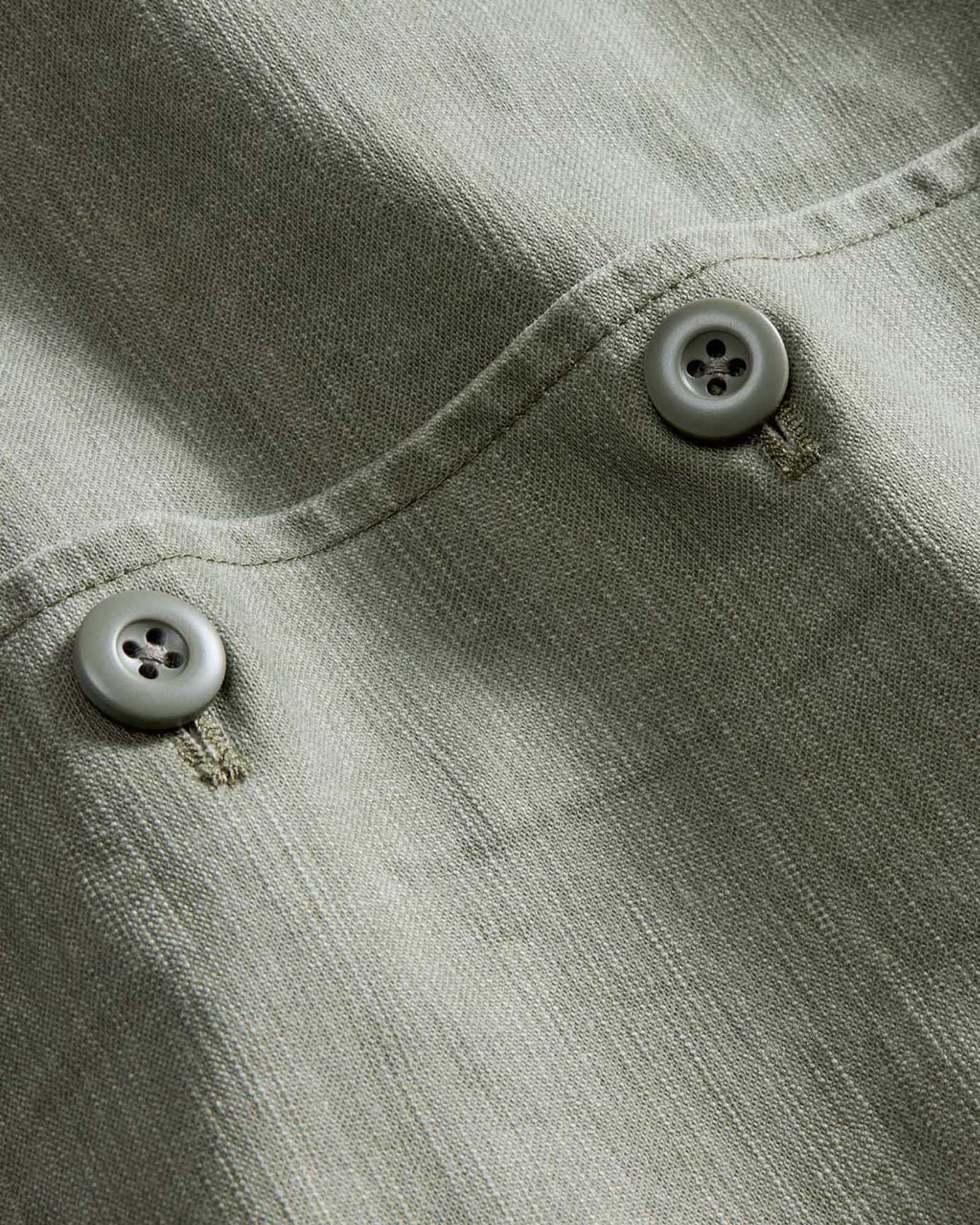 material shot of the buttons on The Short Sleeve Surplus Shirt in Field Olive Reverse Sateen, Wovens by Taylor Stitch