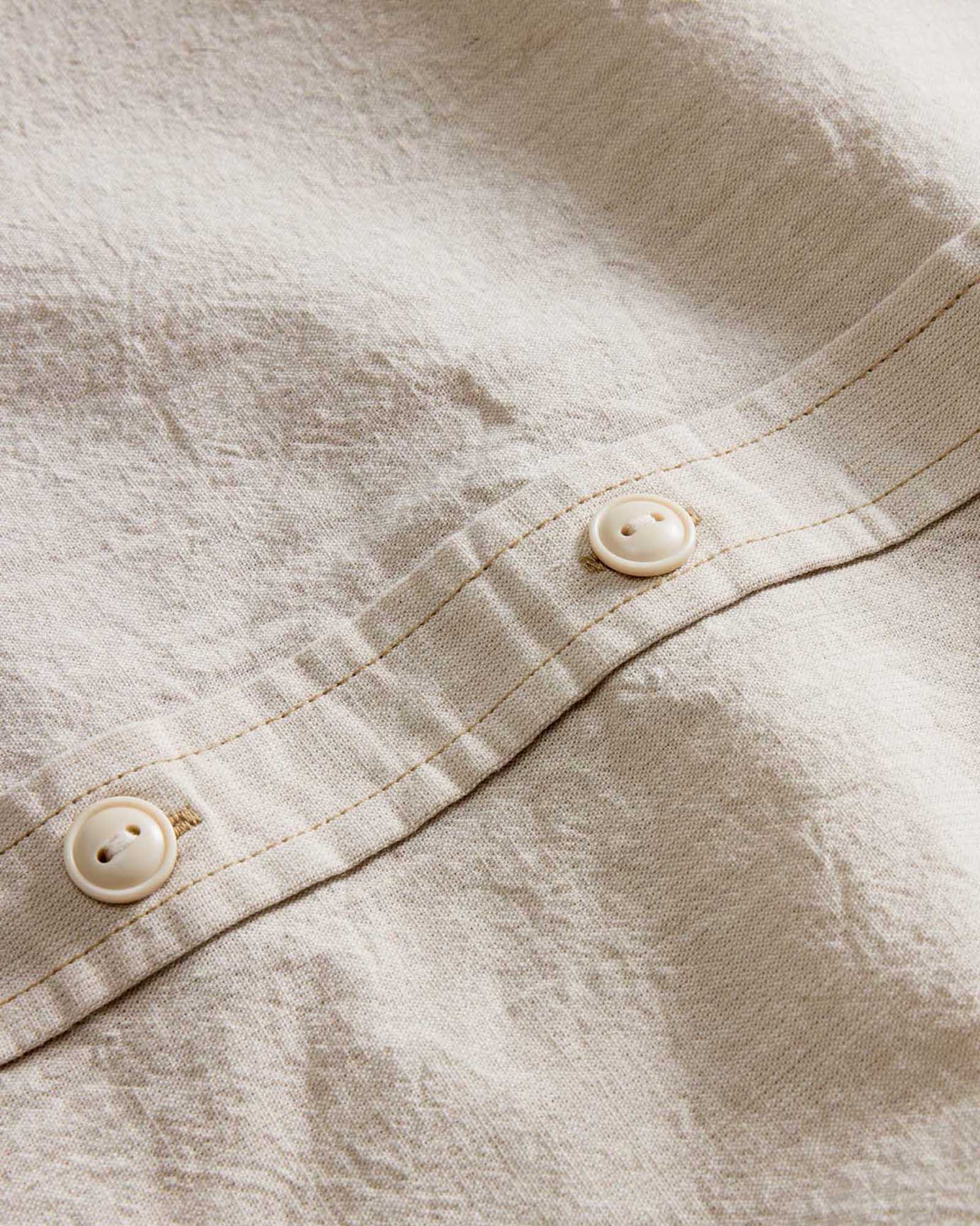 material shot of the buttons on The Short Sleeve Utility Shirt in Natural Selvedge Chambray, Wovens by Taylor Stitch