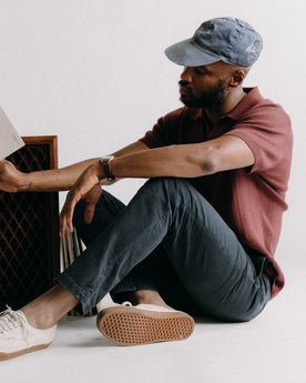 fit model sitting wearing The Slim Foundation Pant in Organic Navy, Bottoms by Taylor Stitch