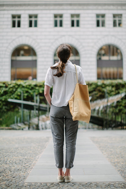 Modelling the pants - yellow tote bag over shoulder, rear view.