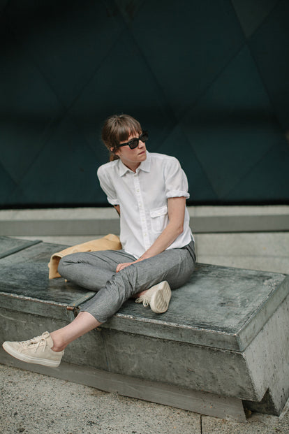 Sitting on a bench, modelling the pants - full length shot.