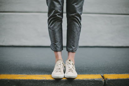 Sitting on a bench, modelling the pants - from, the knees down.