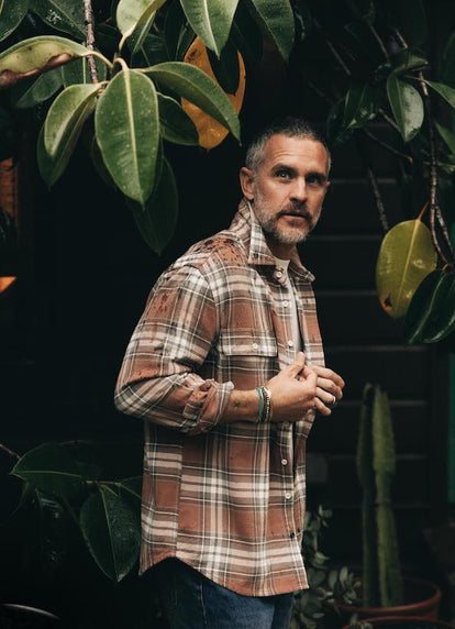 Model adjusting The Ledge Shirt in Sun Bleached Plaid outdoors