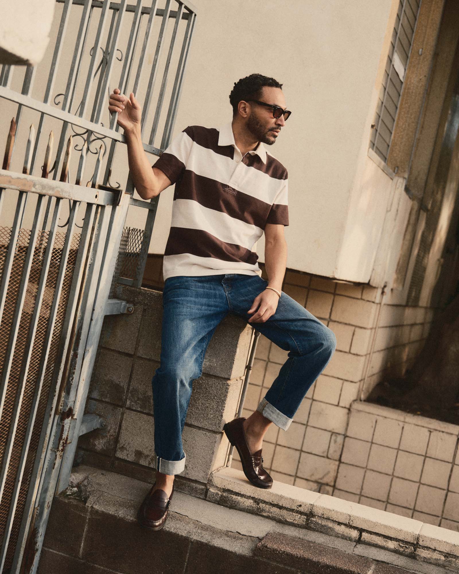 fit model sitting wearing The Short Sleeve Rugby Shirt in Port Stripe, Knits by Taylor Stitch