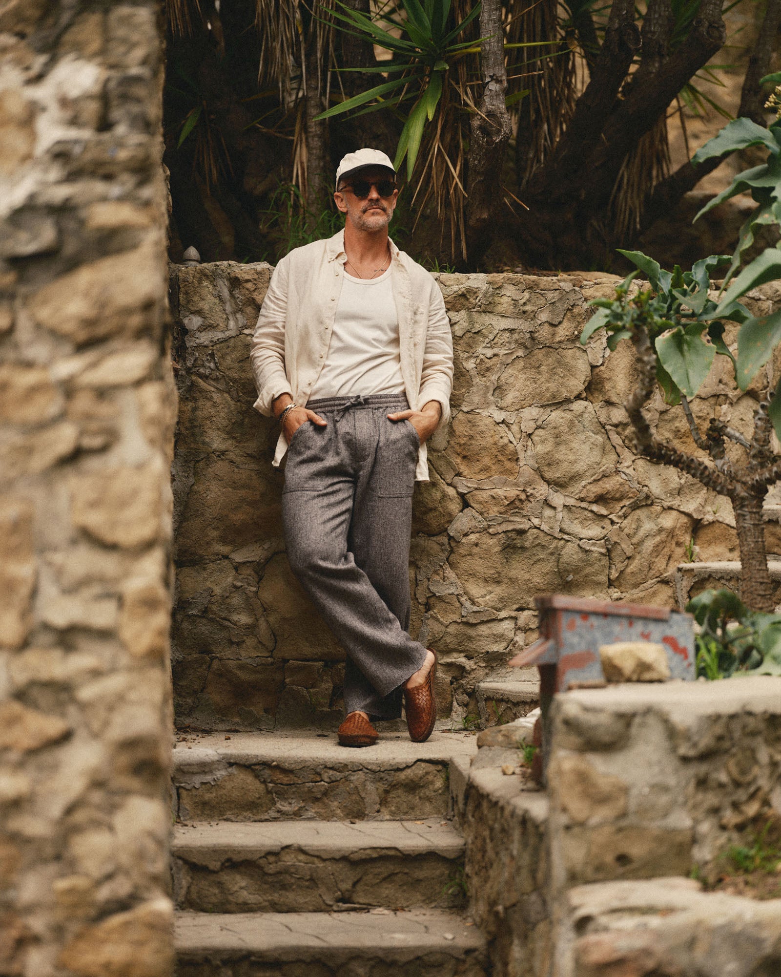 fit model leaning against the wall wearing The Breakwater Pant in Grey Marl Hemp, Bottoms by Taylor Stitch