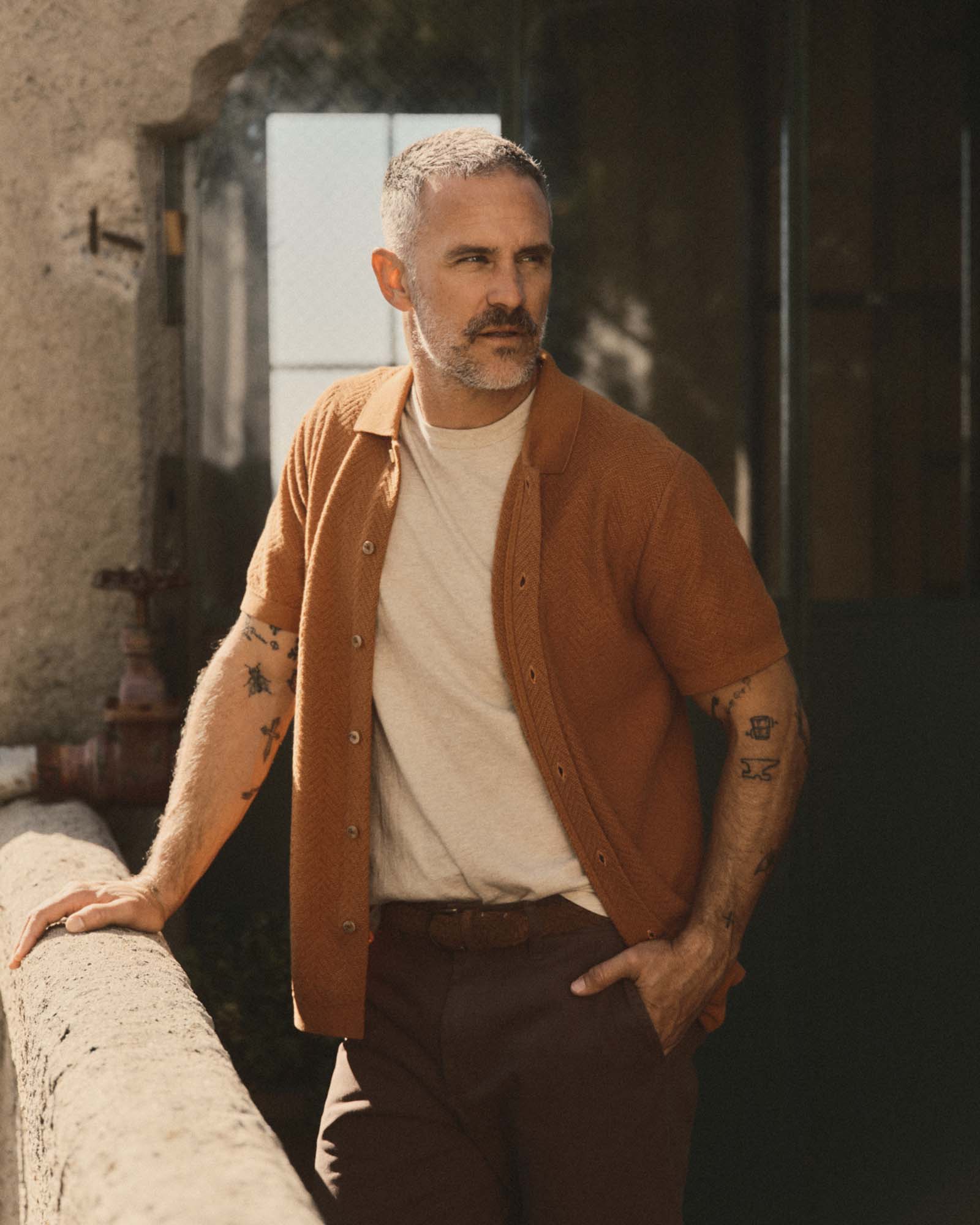 fit model posing in The Button Down Polo in Desert Herringbone, Knits by Taylor Stitch
