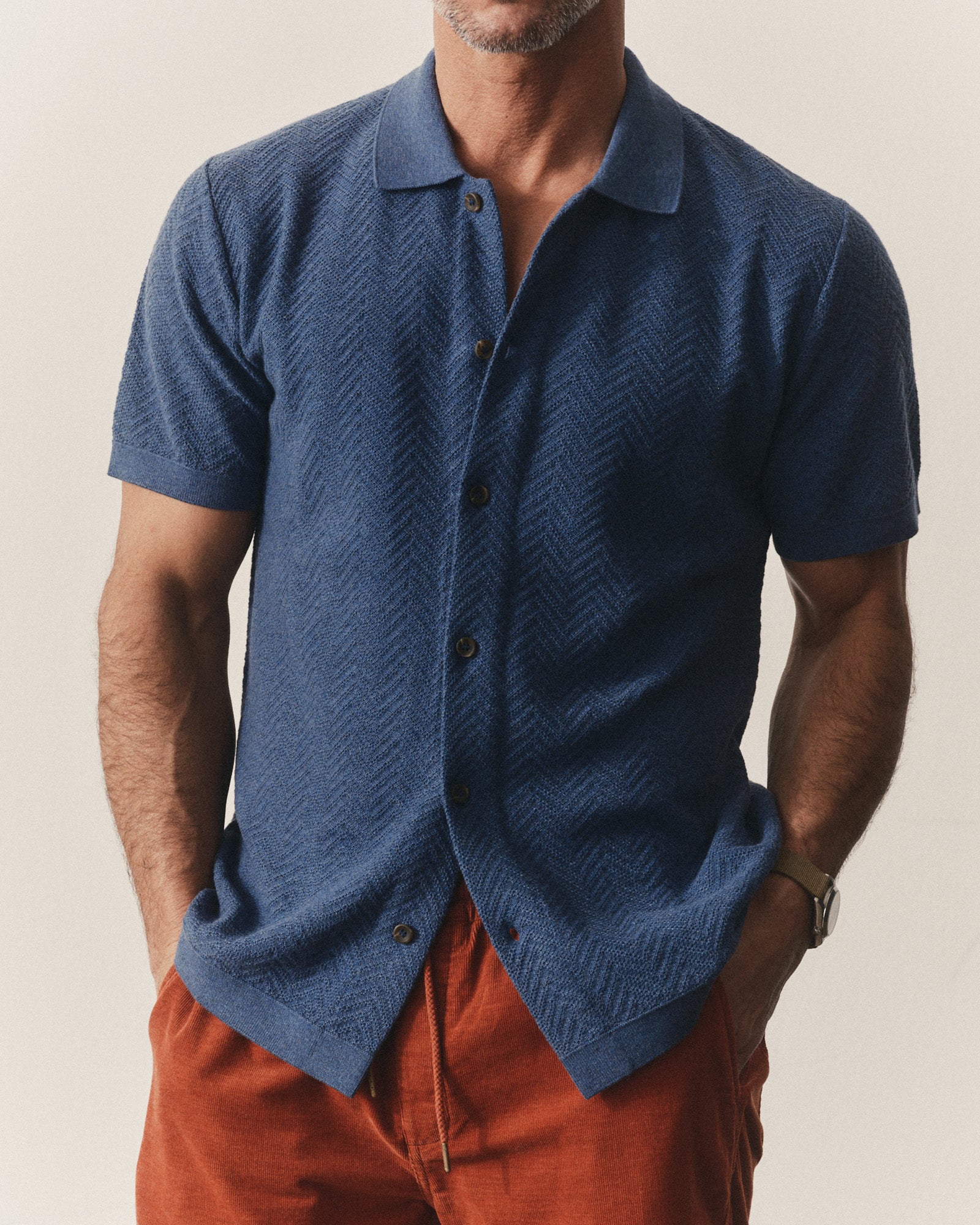 fit model posing in The Button Down Polo in Gulf Stream Herringbone, Knits by Taylor Stitch