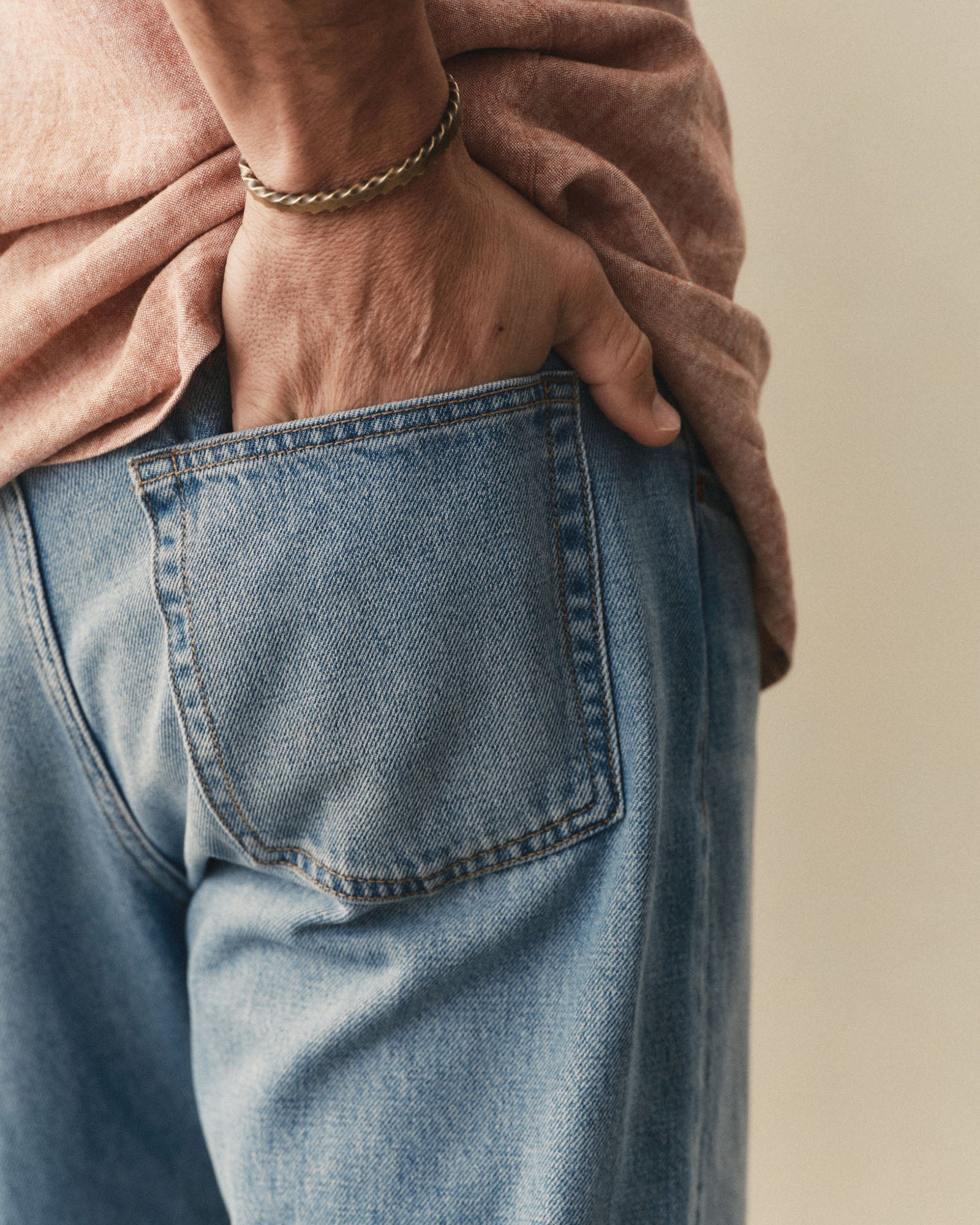 fit model with his hand in his pocket wearing The Democratic Jean in Light Wash Hemp Denim, Bottoms by Taylor Stitch