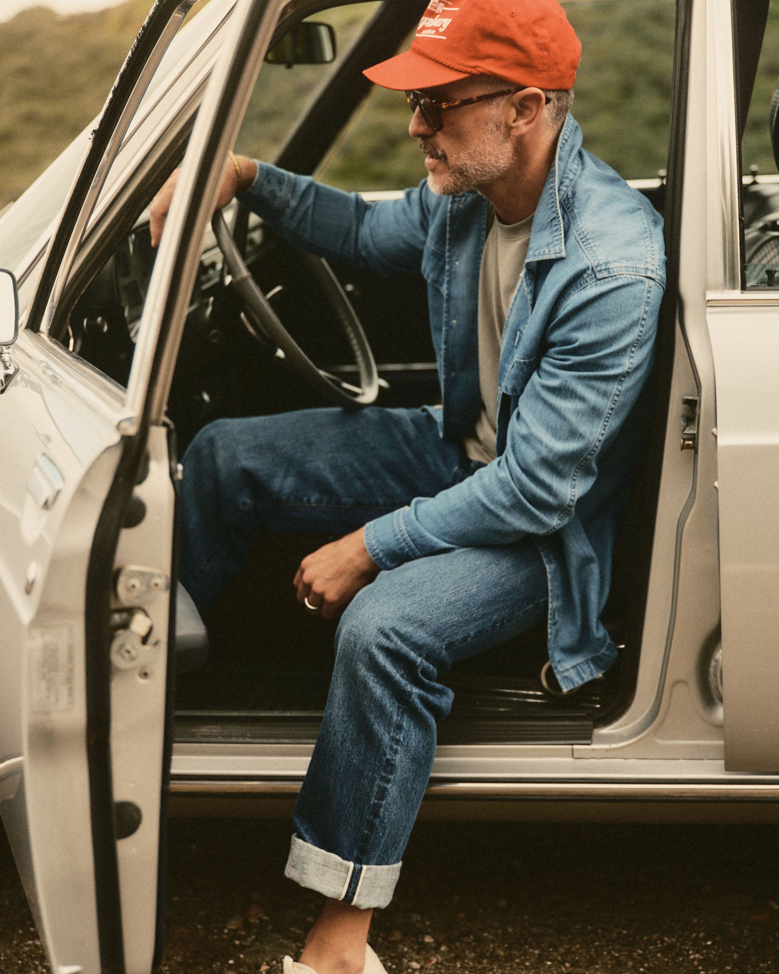 fit model sitting wearing The Shore Shirt in Washed Indigo Twill, Wovens by Taylor Stitch