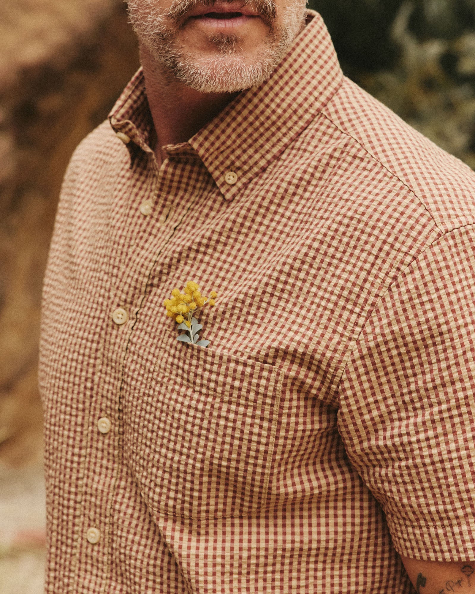 fit model showing off the pocket on The Short Sleeve Jack in Brick Check Seersucker, Wovens by Taylor Stitch