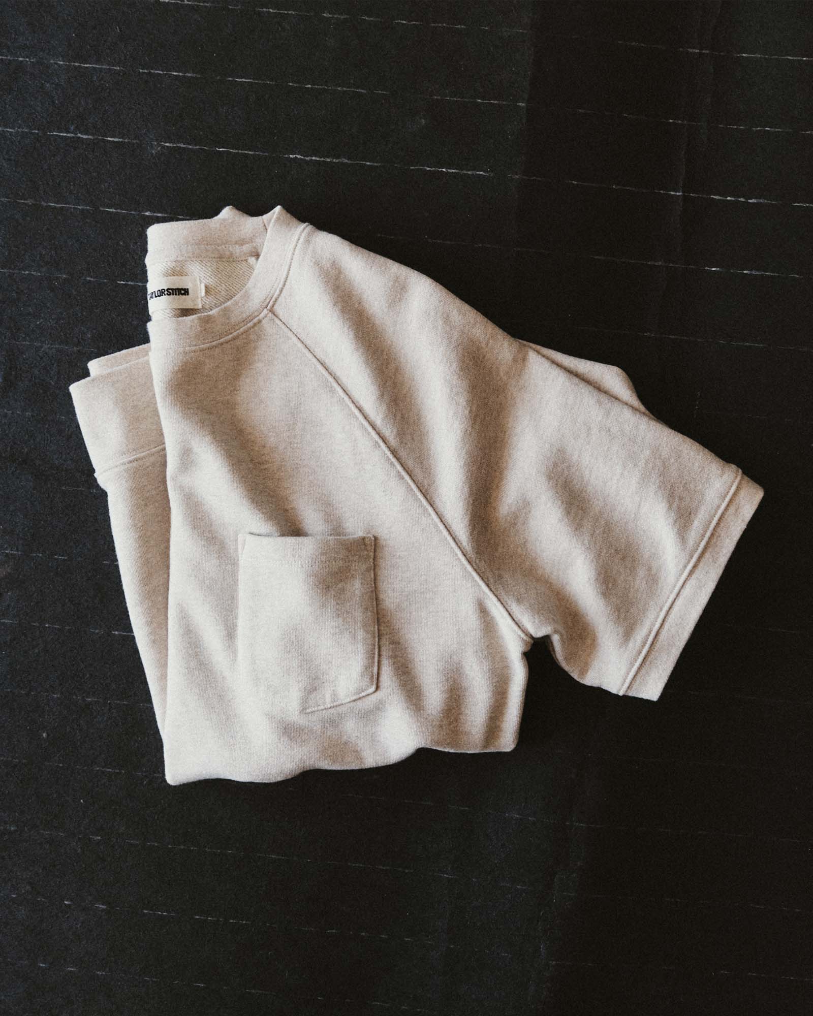editorial flatlay of The Short Sleeve Sunset Crew in Heather Oat Terry folded, Knits by Taylor Stitch