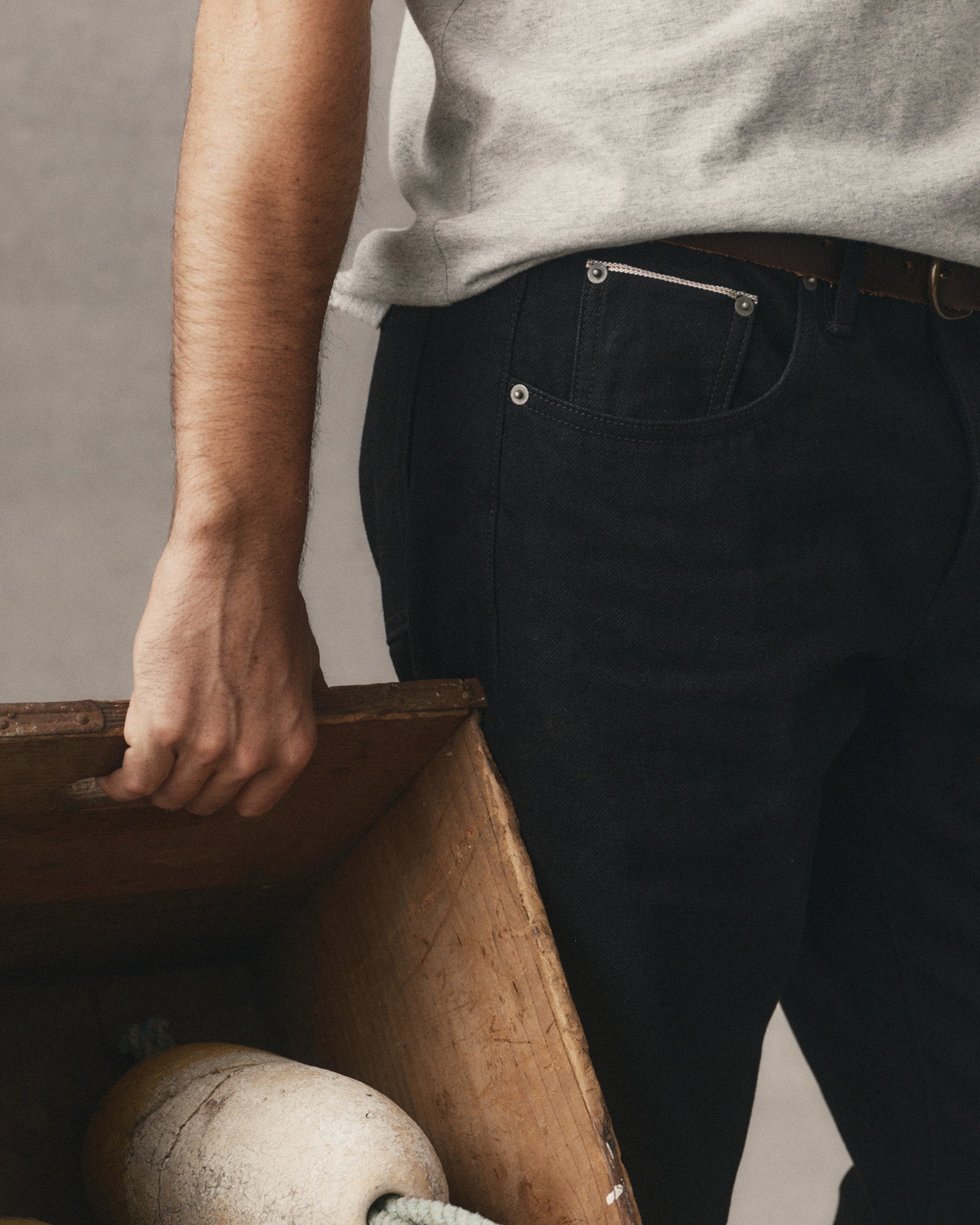 fit model showing off the pocket on The Straight Jean in Rinsed Black Organic Selvedge, Bottoms by Taylor Stitch