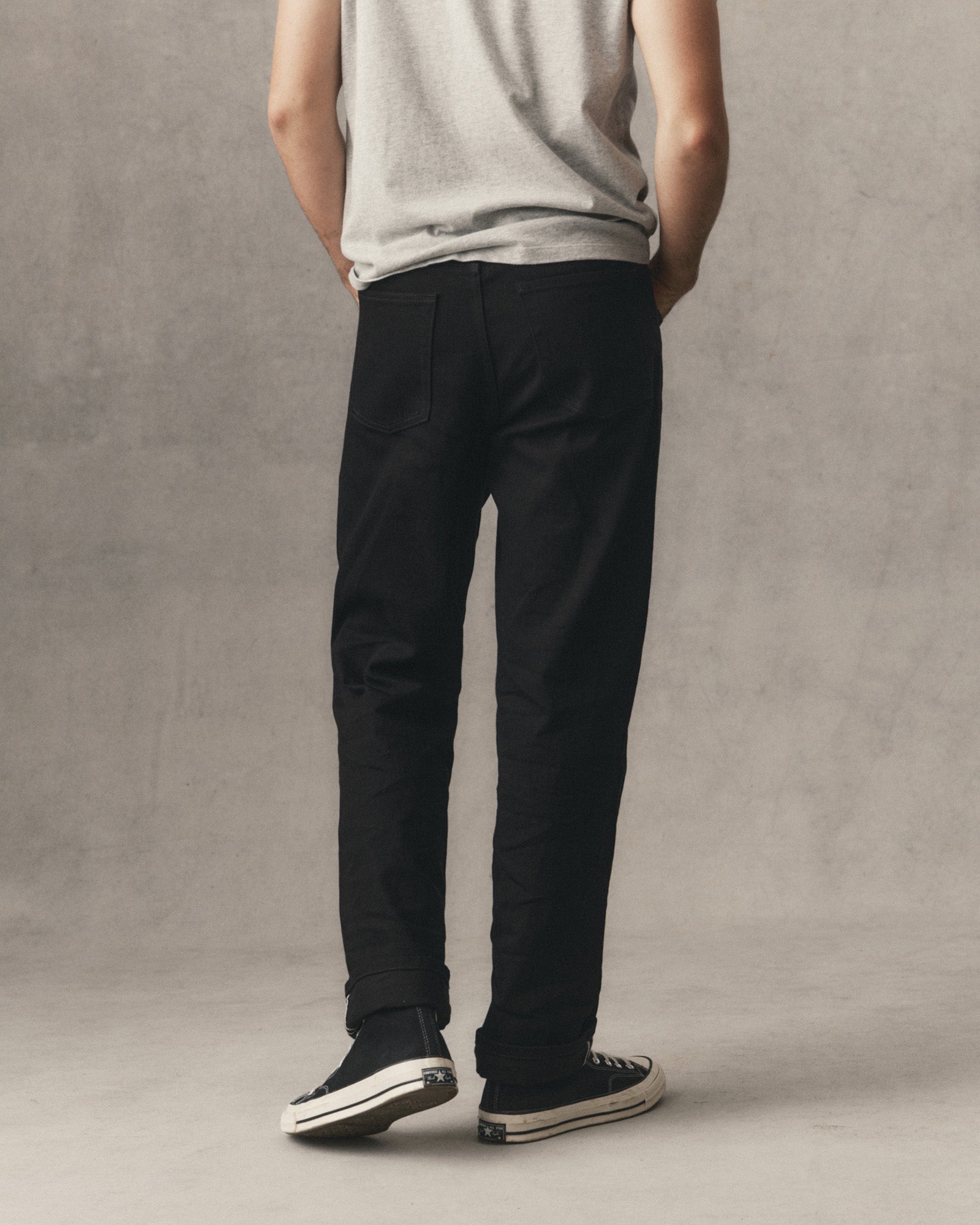 fit model showing off the back of The Straight Jean in Rinsed Black Organic Selvedge, Bottoms by Taylor Stitch