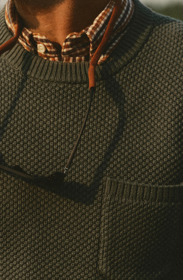fit model showing off the pocket on The Crawford Crew Sweater in Fatigue Olive