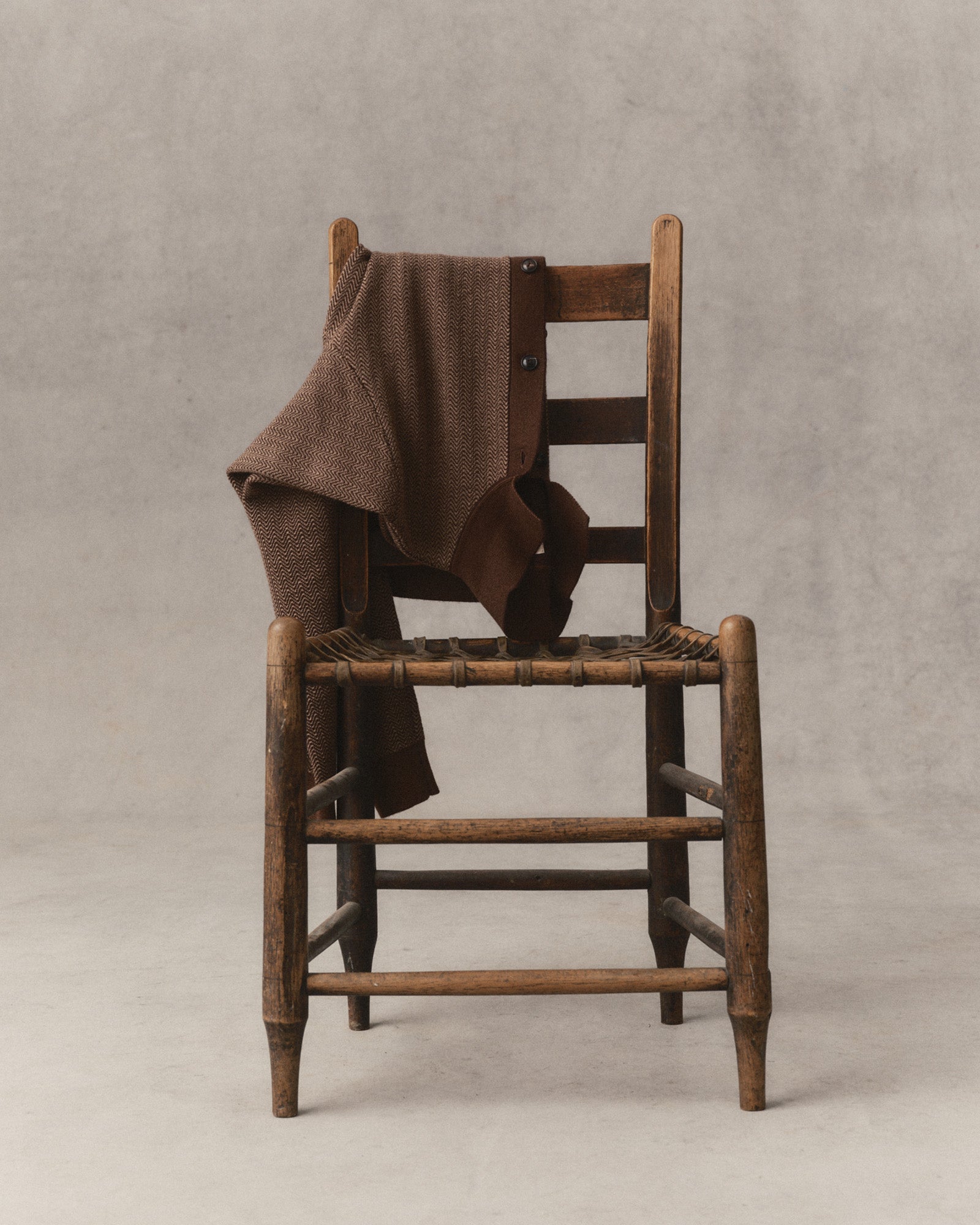 editorial image of The Miles Sweater Polo in Espresso Merino on a chair The Miles Sweater Polo in Espresso Merino, Sweaters by Taylor Stitch