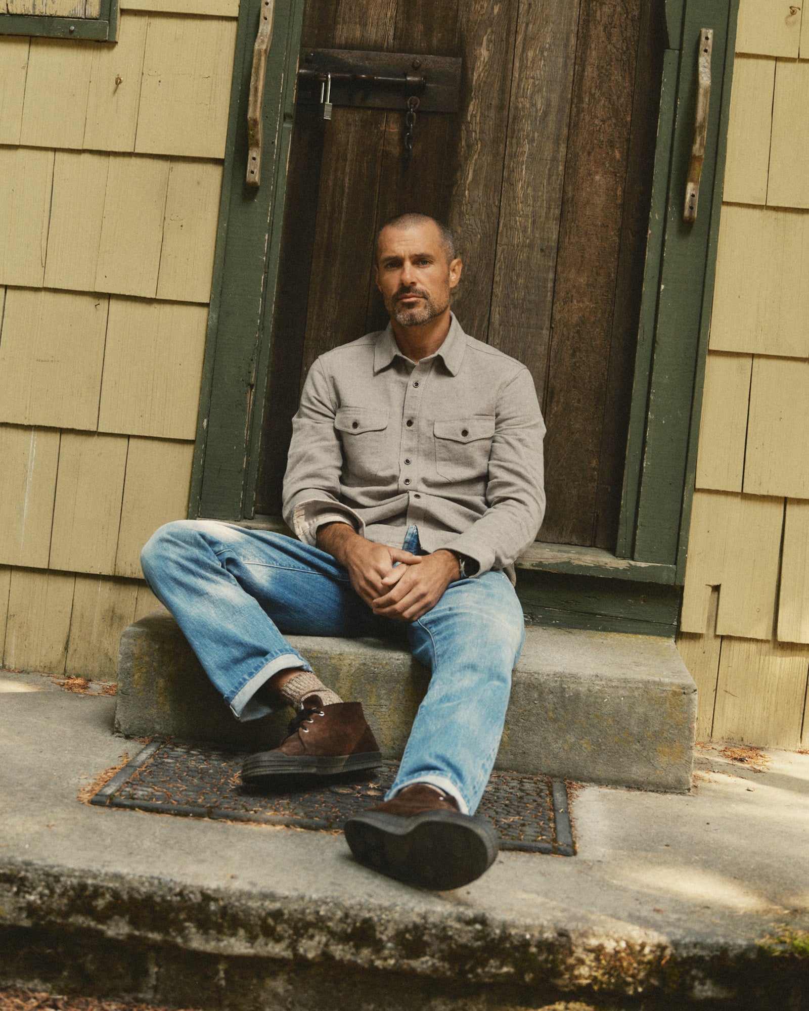 fit model sitting wearing The Redding Shirt in Boulder Marl Hemp, Wovens by Taylor Stitch