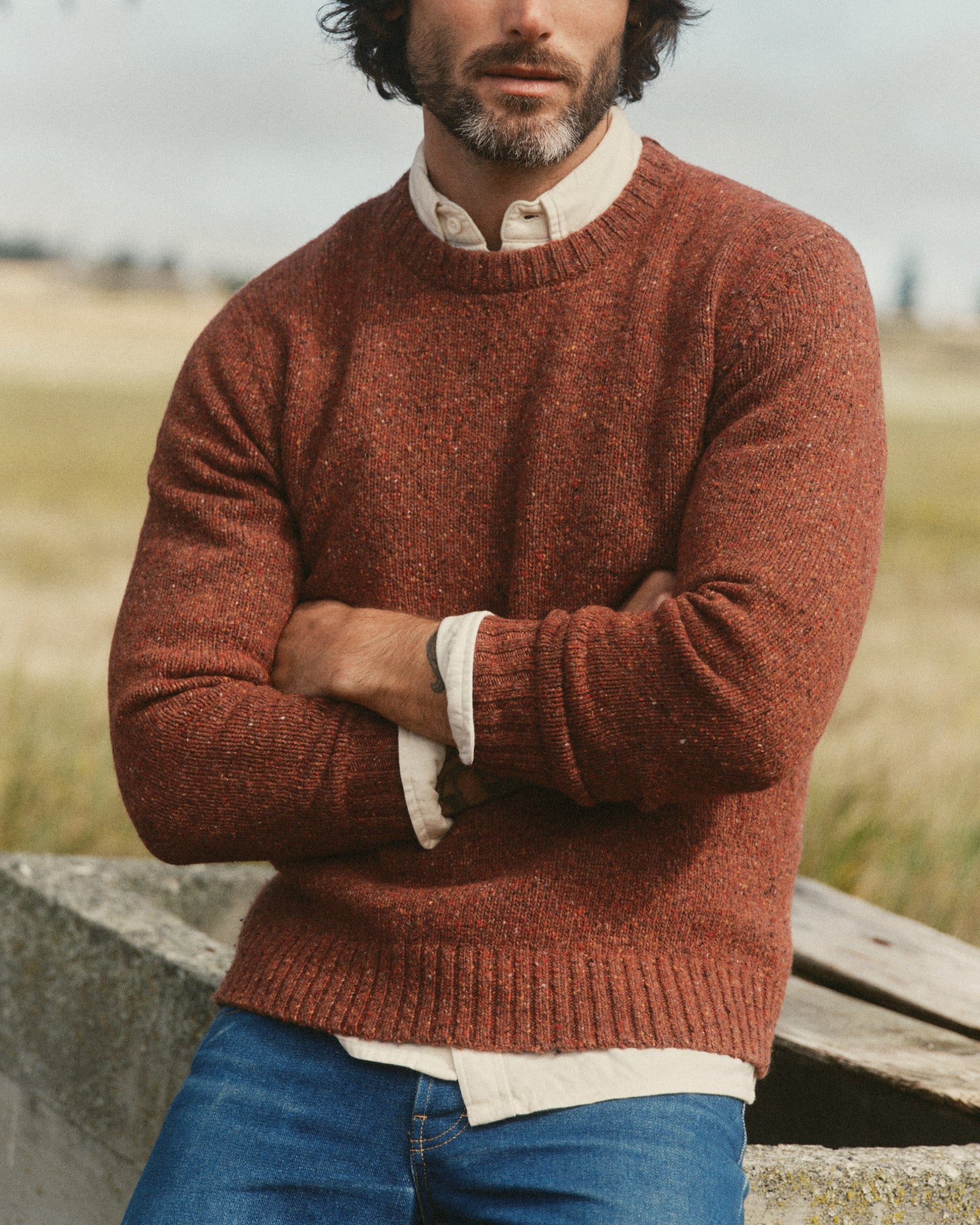 fit model sitting wearing The Seafarer Crew Sweater in Ember Donegal, Sweaters by Taylor Stitch