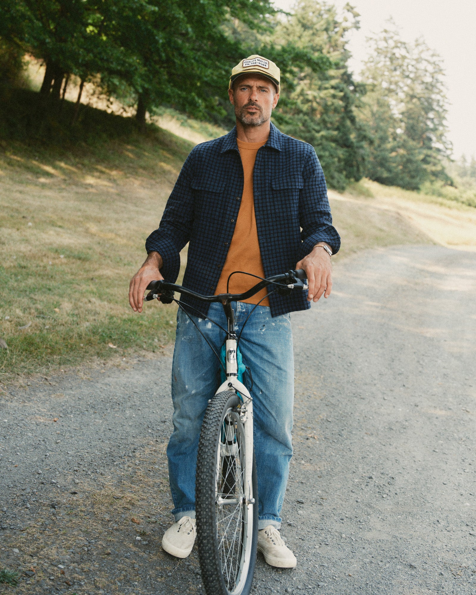 fit model on a bike wearing The Shore Shirt in Midnight Check Wool, Wovens by Taylor Stitch