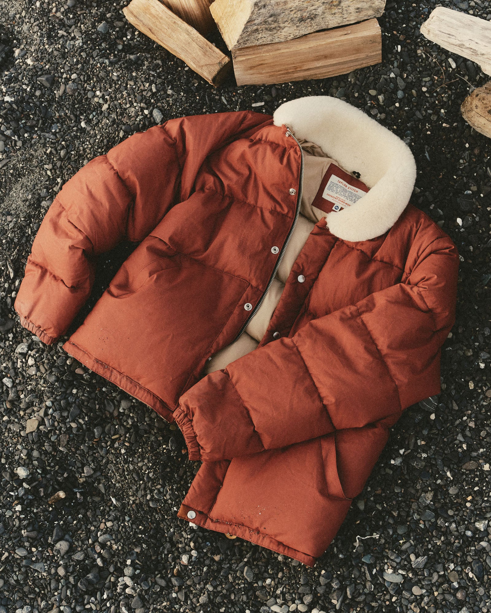 editorial flatlay of The Down Sweater Jacket in Brick Red Waxed Ripstop, Outerwear by Taylor Stitch
