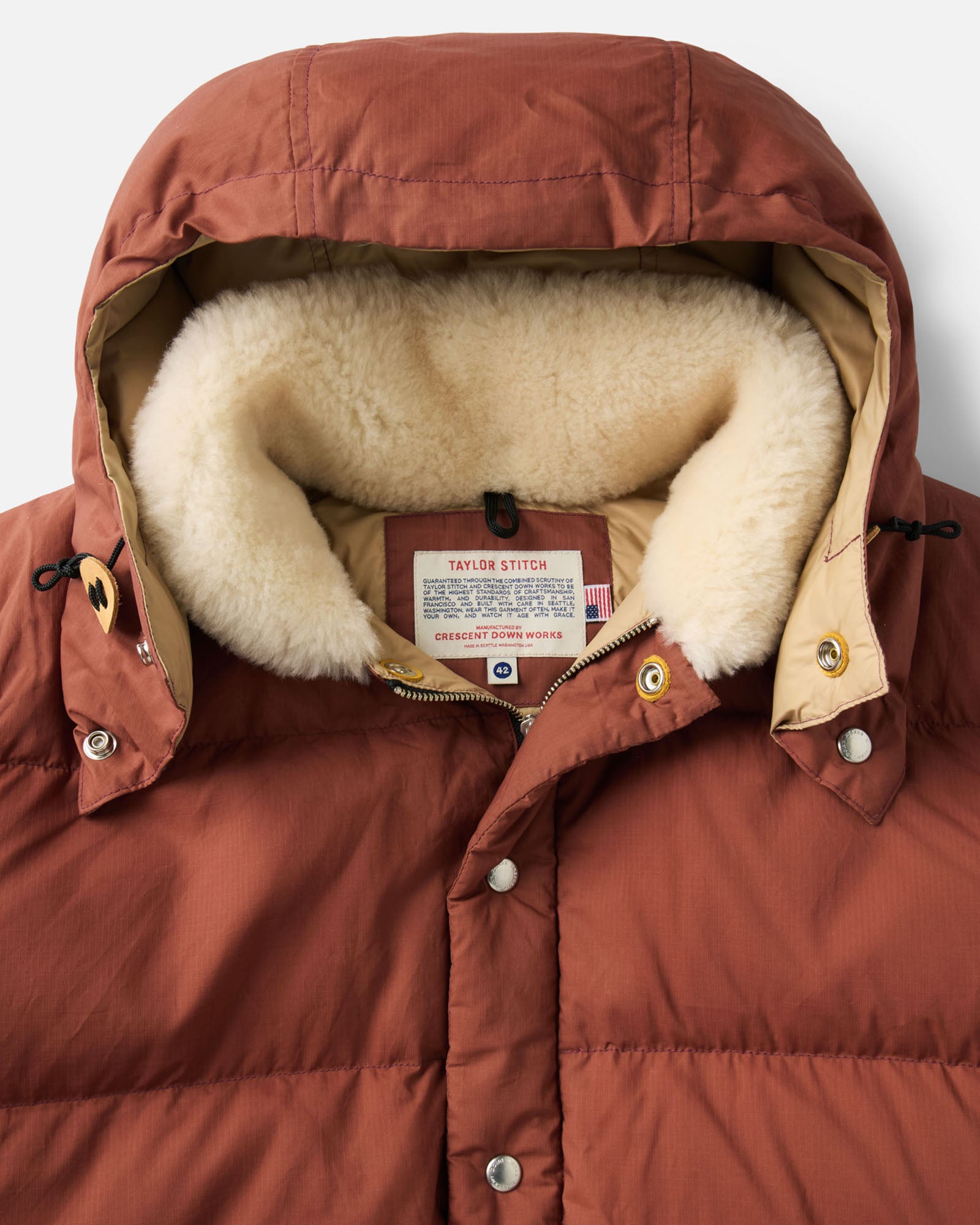 material shot of the sleeve on The Down Sweater Jacket in Brick Red Waxed Ripstop, Outerwear by Taylor Stitch