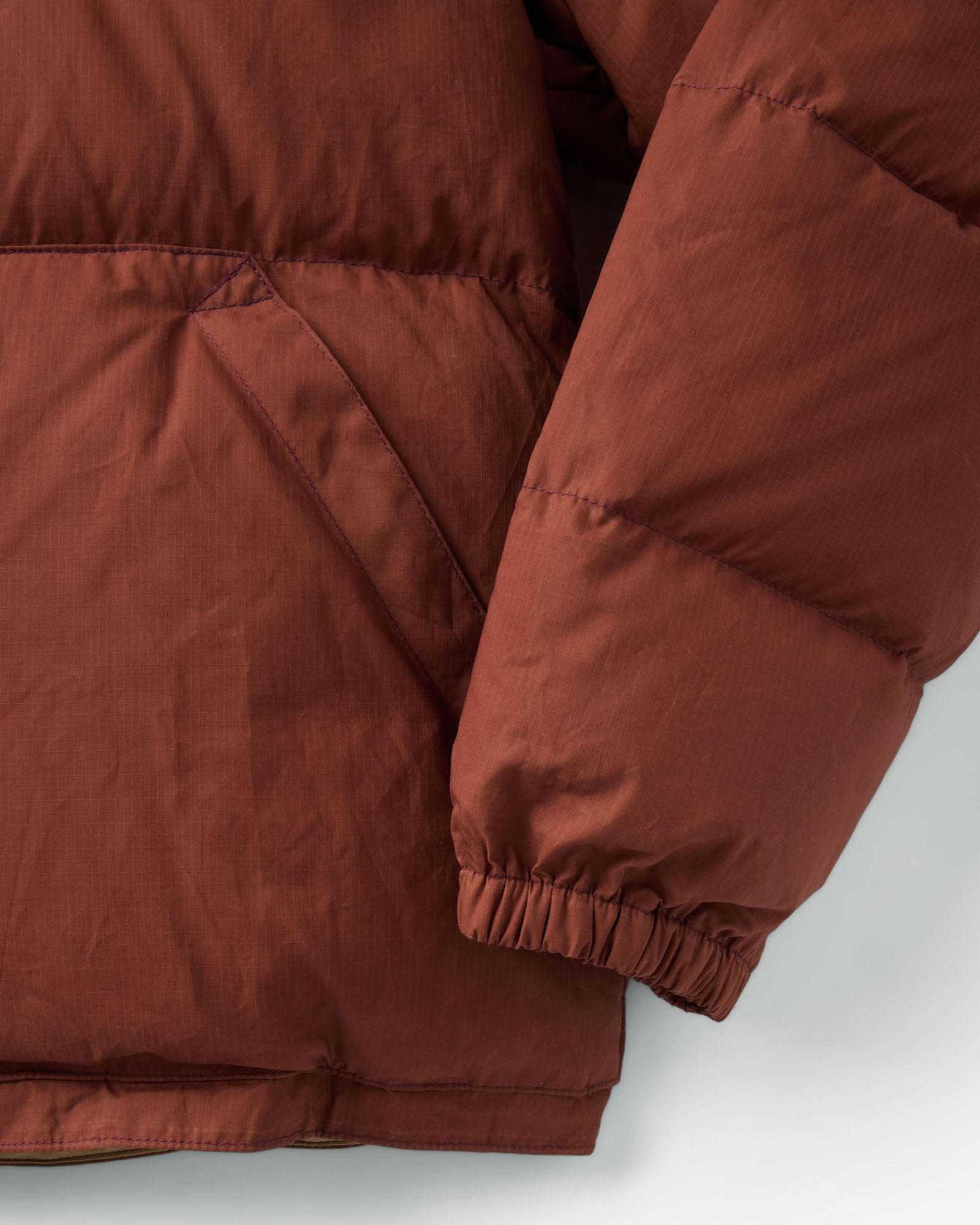 material shot of the buttons on The Down Sweater Jacket in Brick Red Waxed Ripstop, Outerwear by Taylor Stitch