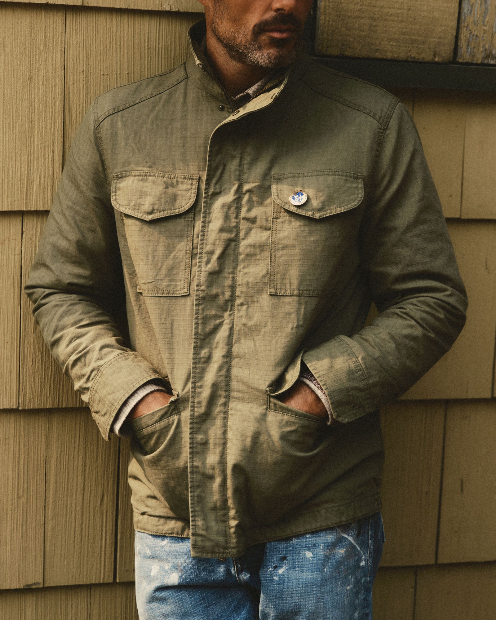 fit model with his hands in the pockets of The Field Jacket in Burnt Olive Ripstop, Outerwear by Taylor Stitch