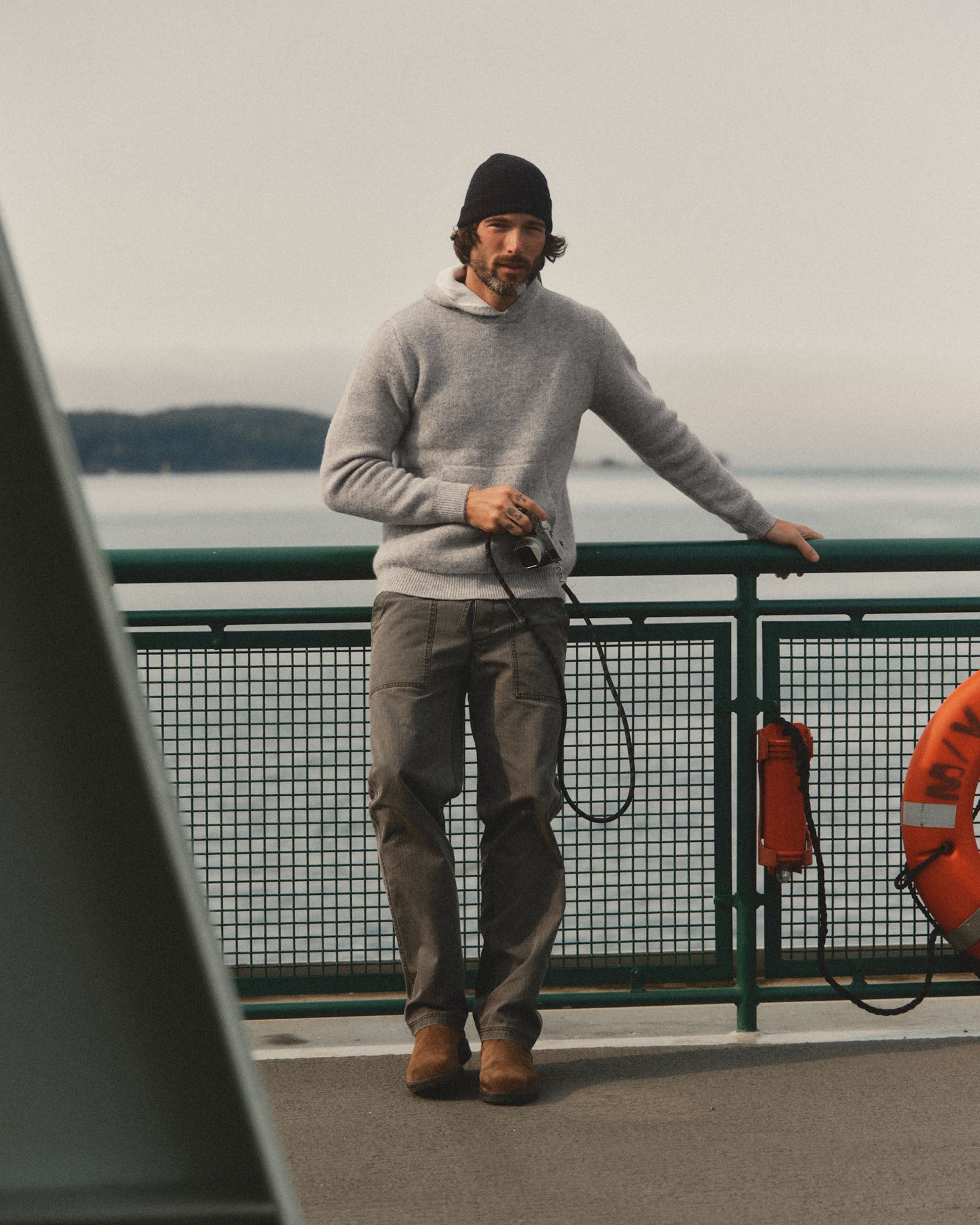 fit model leaning against the wall wearing The Haven Sweater Hoodie in Heather Grey Wool, Sweaters by Taylor Stitch