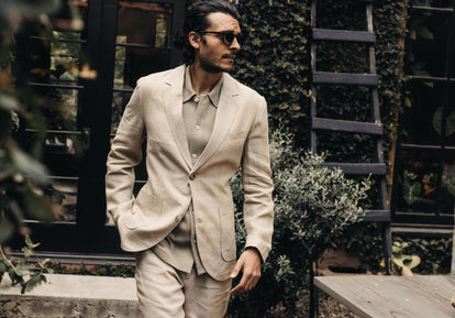fit model walking in The Sheffield Sport Coat and Trouser in Natural Linen and The Button Down Polo in Arid Eucalyptus Seed Stitch
