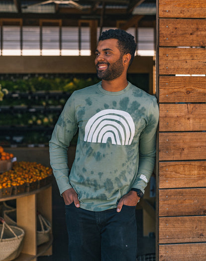 Volunteer at The Ecology Center holding a crate of oranges in The Long Sleeve Organic Cotton Tee in Ecology Center