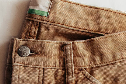 editorial image of the button on The Good Acre Chore Pant in Tan Canvas