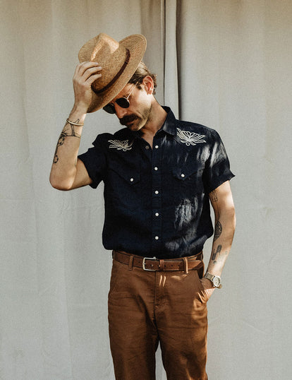 Daren Magee tipping his hat in The Embroidered Short Sleeve Western in Indigo Linen