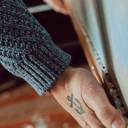 Zach adjusting his easel while wearing The Adirondack Sweater in Blue Melange.