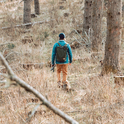 Zach hiking in the woods wearing The Ojai Jacket in Sawyer Wash and The Chore Pant in Tobacco Boss Duck.