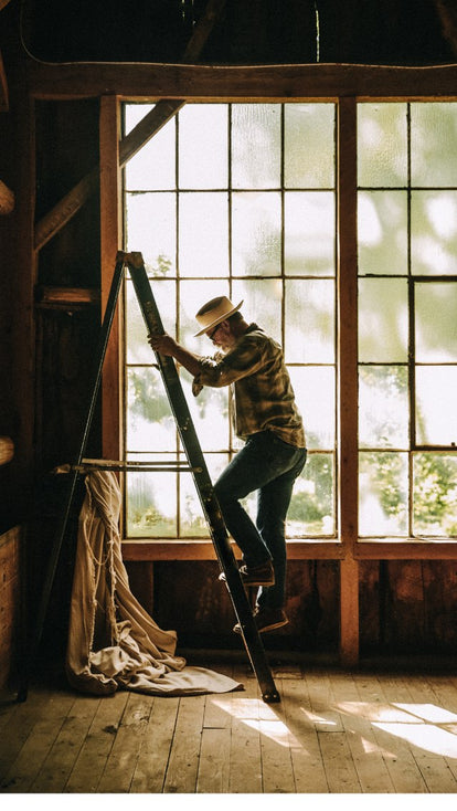 Mark Holthusen climbing down a ladder in the barn