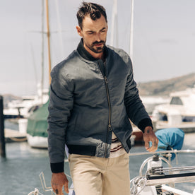 fit model walking on a boat in The Bomber Jacket in Charcoal Dry Wax
