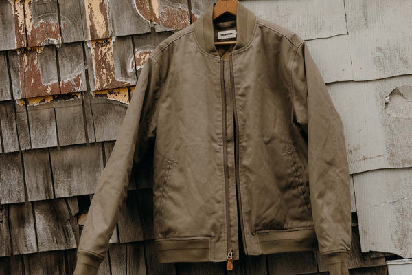 editorial image of The Insulated Bomber Jacket in Fatigue Olive Dry Wax hanging