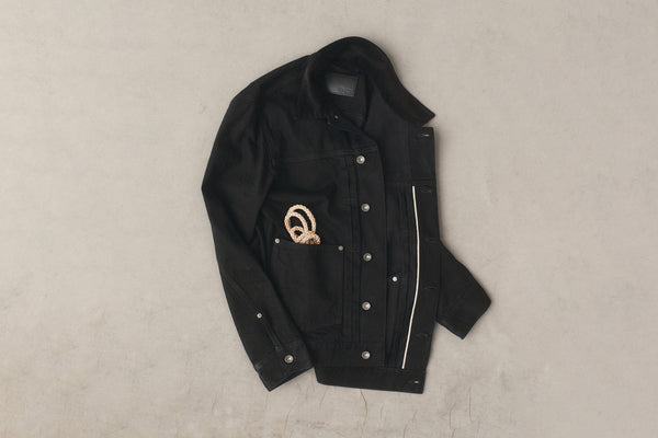 editorial flatlay of black selvedge denim jacket