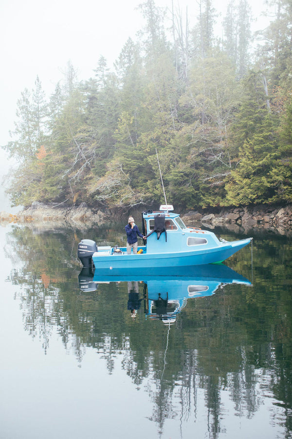 Long shot of the boat lit up on a glassy night.