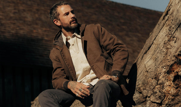 fit model sitting wearing The Workhorse Hoodie in Aged Penny Chipped Canvas