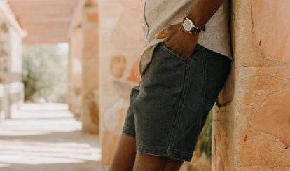 fit model leaning against the wall wearing The Camp Short in Navy Chipped Canvas