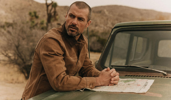 fit model leaning against a car in The Ryder Jacket in Tobacco Chipped Canvas