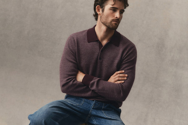 fit model sitting wearing The Sweater Polo in Burgundy