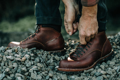 man wearing the backcountry boot on a gravel pile