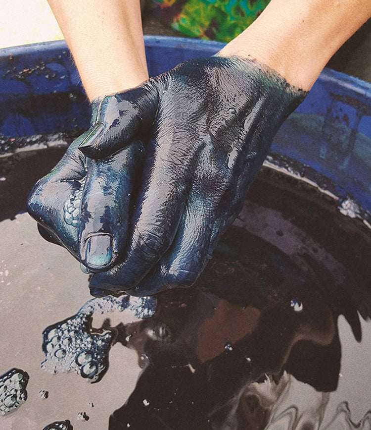 Close up shot of hands working with blue dye.