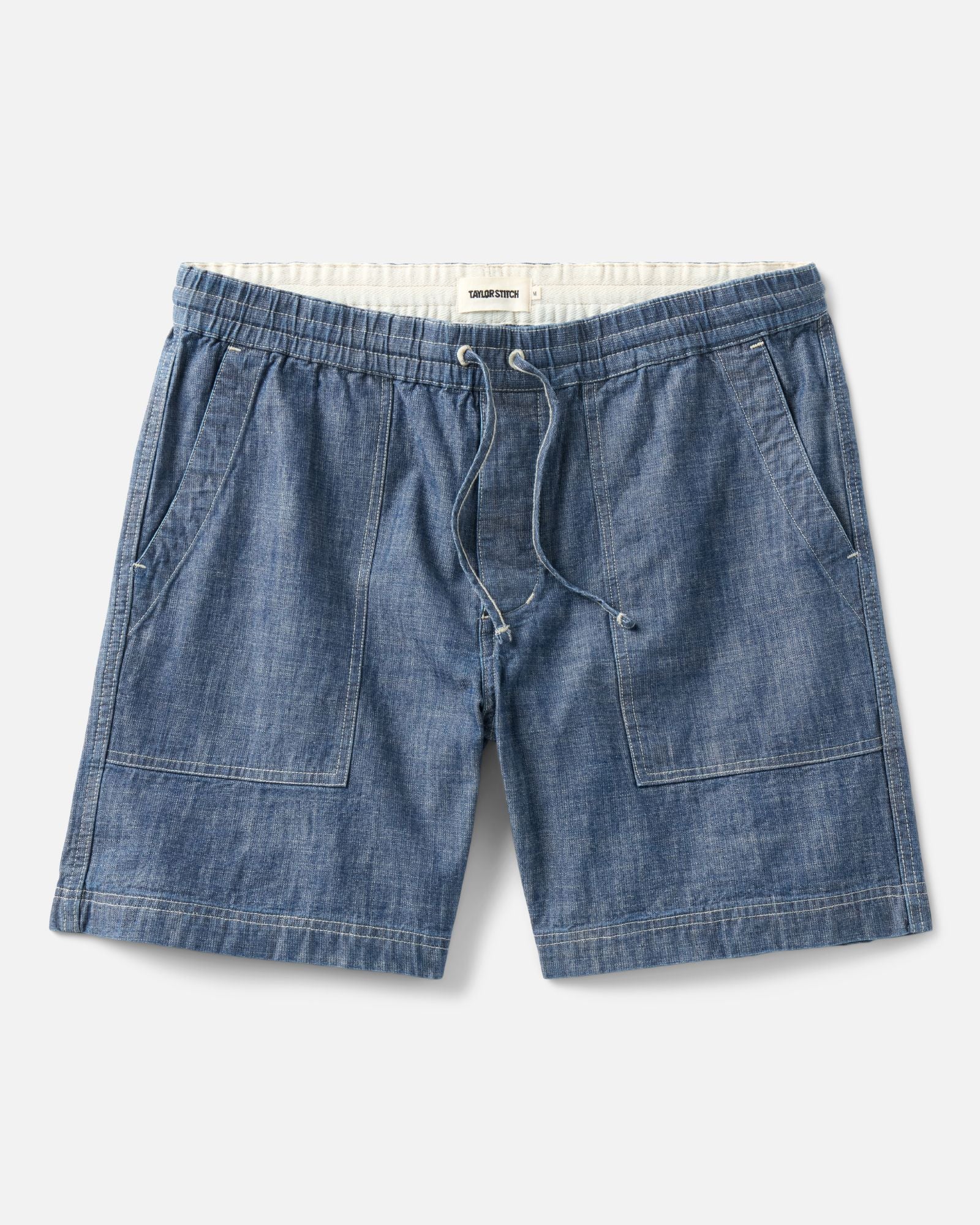 flatlay of The Breakwater Short in Washed Indigo Chambray, Bottoms by Taylor Stitch