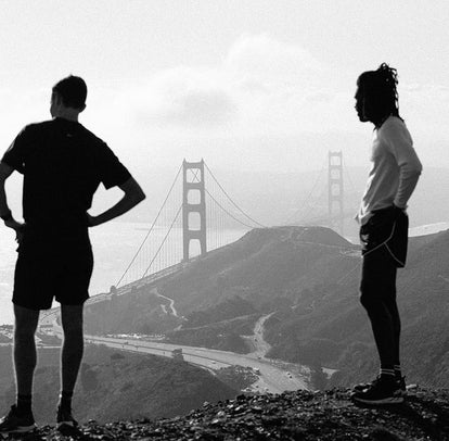 Two guys trail running, with The Golden Gate Bridge in the background.