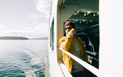A man in the Lombardi Jacket riding a ferry in the Pacific Northwest.