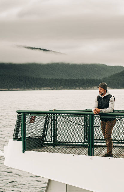 A man riding a ferry over the water.